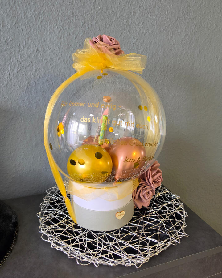 Geschenkballon mit Überraschung und gelber Schleife